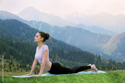 Yoga outdoors - woman doing yoga Surya Namaskar. © Roman