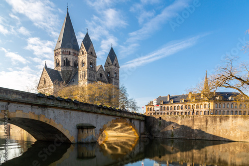 Pont des Roches bridge and Temple neuf - New Protestant church, German Imperial monument of Alsace-Lorraine in Ville de Metz city, Grand Est, France. Sun rays reflect in the waters of Moselle river © Dmitry