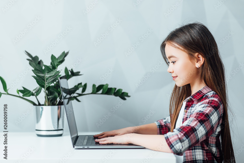 Little girl sitting at table and using modern tablet ! Little girl sitting at table and using modern tablet !