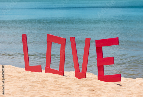 design of letters Love on the beach. The concept of loves and travel. Big letters Love on the sandy beach and on the sea background