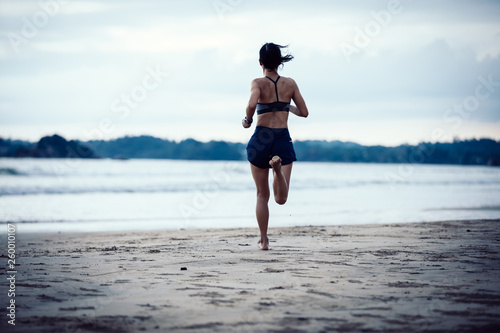  young fitness woman running at beach