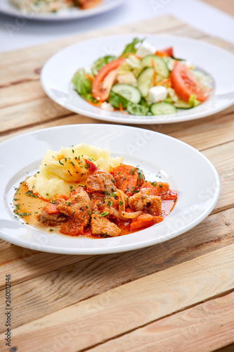 chicken with mashed potatoes and salad on the wooden background