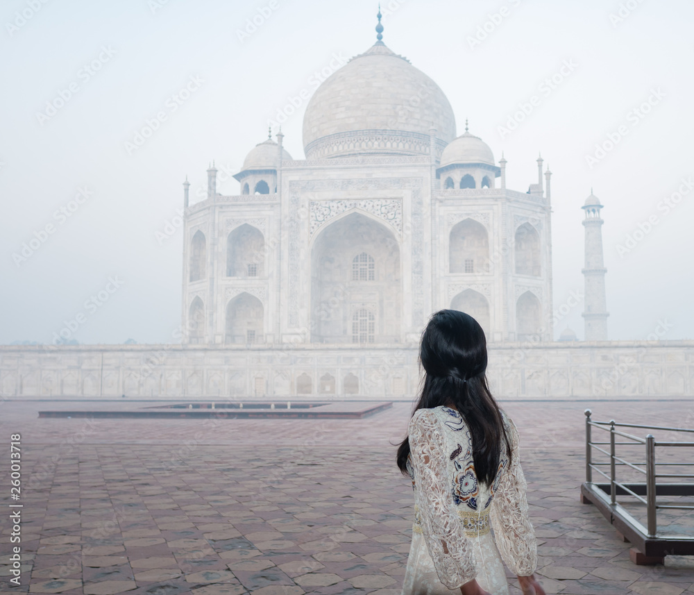 Obraz premium woman with white long dress in Taj Mahal in foggy morning