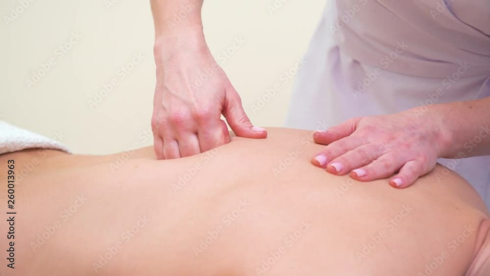 female hands doing professional back massage for male customer in spa salon female hands doing professional back massage for male customer in spa salon