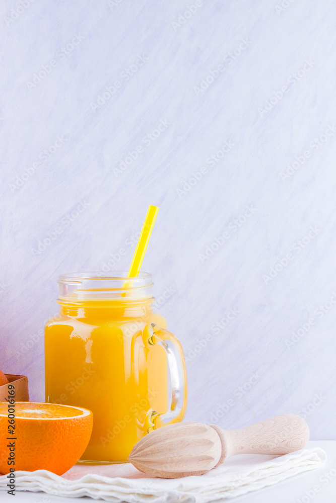 Orange fruits and juice on white background. Citrus fruit for making juice with manual juicer. Oranges in wooden box on white napkin. Mason jar with orange juice Orange fruits and juice on white background. Citrus fruit for making juice with manual juicer. Oranges in wooden box on white napkin. Mason jar with orange juice