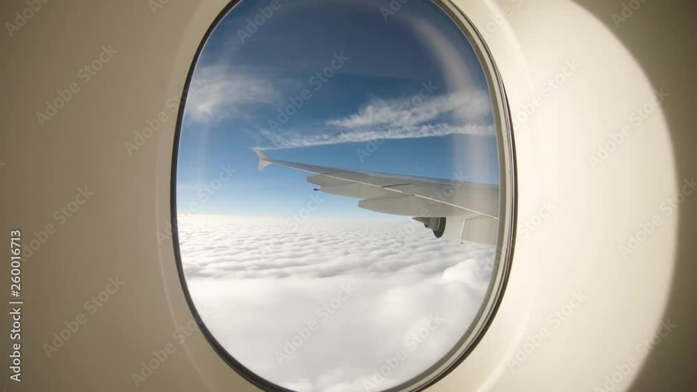 Passenger view from the airplane window high above the clouds Passenger view from the airplane window high above the clouds