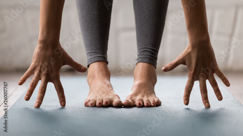 Woman practicing yoga, uttanasana pose, Head to knees close up