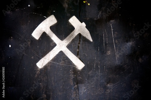 Weißes Hammer und Schlegel Symbol auf schwarzem Metall einer Lore photo