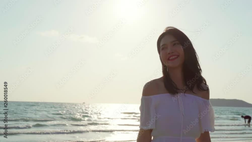 Slow motion - Young Asian woman walking on beach. Beautiful female happy relax walking on beach near sea when sunset in evening. Lifestyle women travel on beach concept. Slow motion - Young Asian woman walking on beach. Beautiful female happy relax walking on beach near sea when sunset in evening. Lifestyle women travel on beach concept.