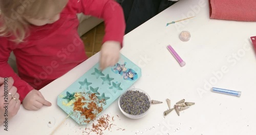 Making soap from glicerine and dry flowers. DIY at home with children. photo