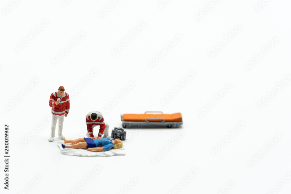 Obraz premium Miniature people, emergency medical team with unconcious patient and pills on the ground. Concept of health care, emergency, life insurance, accident background