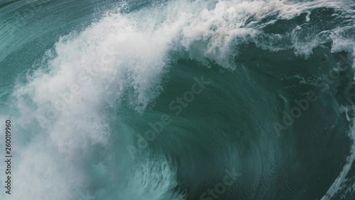 A close up look inside a heavy wave breaking in slow motion along a shallow reef break. photo