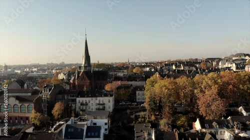 Flying above Wiesbaden: a group of doves are circuling around a drone on a sunny morning. The background is the capital of Hesse in Germany. photo