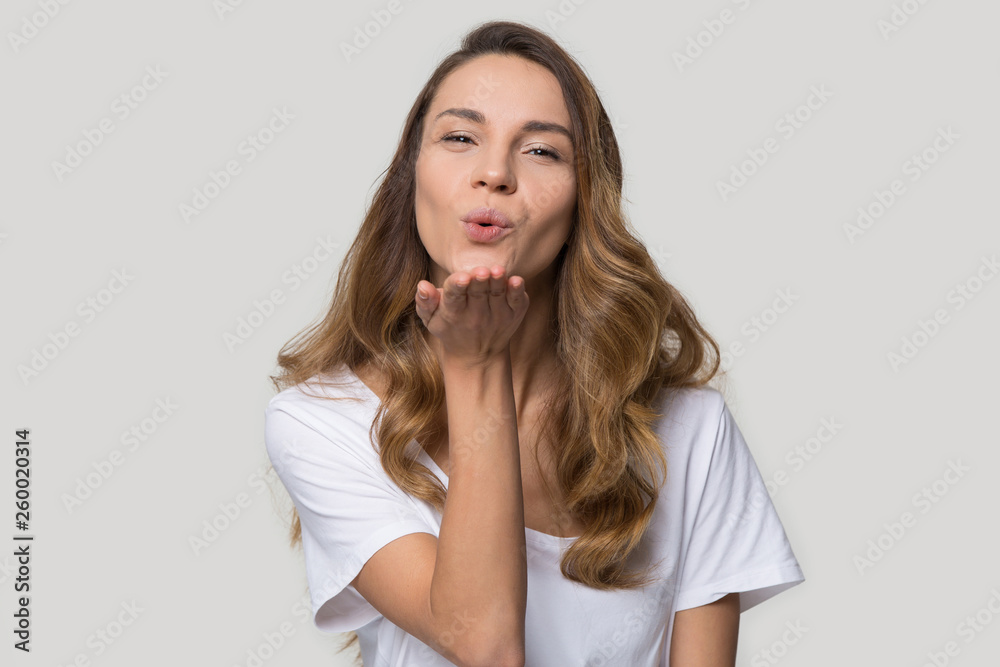 Beautiful millennial woman makes air kiss pose in studio Beautiful millennial woman makes air kiss pose in studio