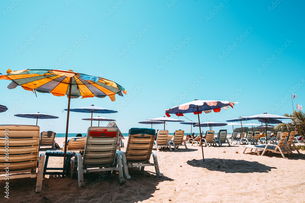 Sunbeds on tropical beach with calm sky. sea view and sand beach, summer background. vintage color tone effect