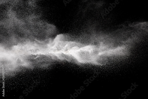 Freeze motion explosion of white powder on a black background.Stopping the movement of white dust on dark background.