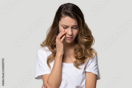 Sad depressed young woman in tears studio headshot