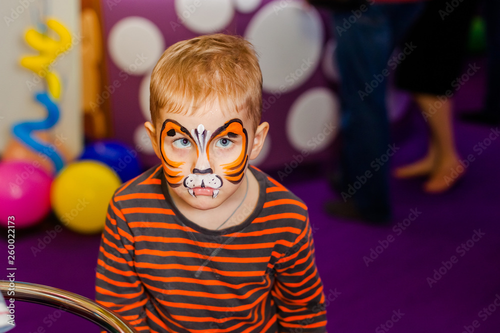 Child animator, artist's hand draws face painting to little boy. Child with funny  face painting. Painter makes orange tiger at boy's face. Children holiday,  event, birthday party, entertainment Stock Photo | Adobe