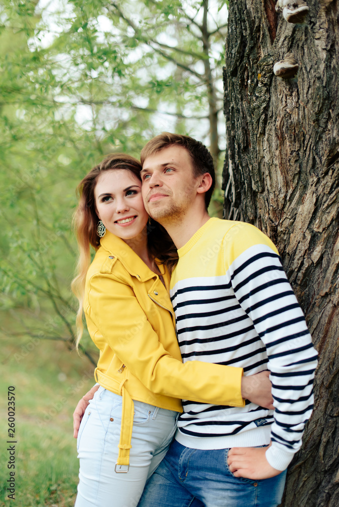 young couple in love in yellow clothes on nature against the background of a tree 1 young couple in love in yellow clothes on nature against the background of a tree 1
