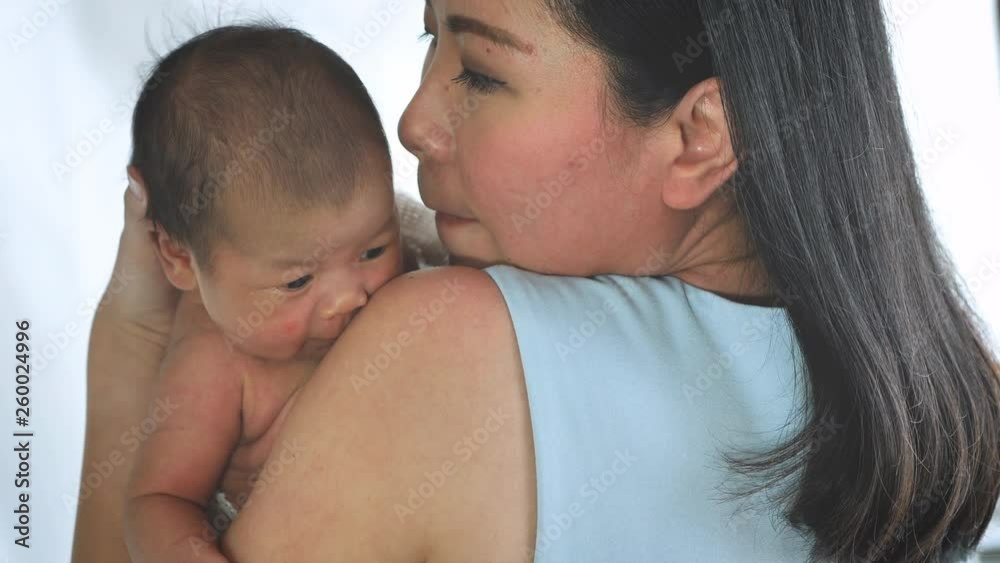 Close up portrait of beautiful young mother asian carrying little baby girl in home and sunlight in the morning. Healthcare, love, relationship concept. Slow Motion Close up portrait of beautiful young mother asian carrying little baby girl in home and sunlight in the morning. Healthcare, love, relationship concept. Slow Motion