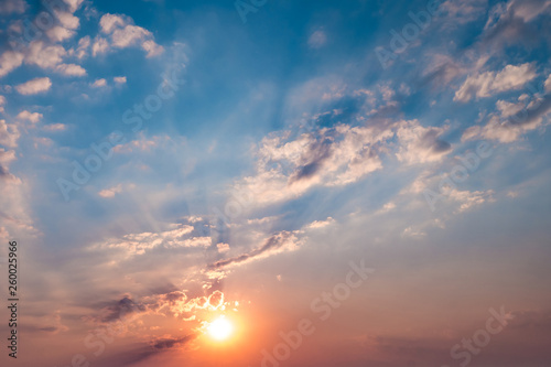 Blue sky background with evening fluffy curly rolling altocumulus altostratus clouds with setting sun. Good windy weather © hiv360