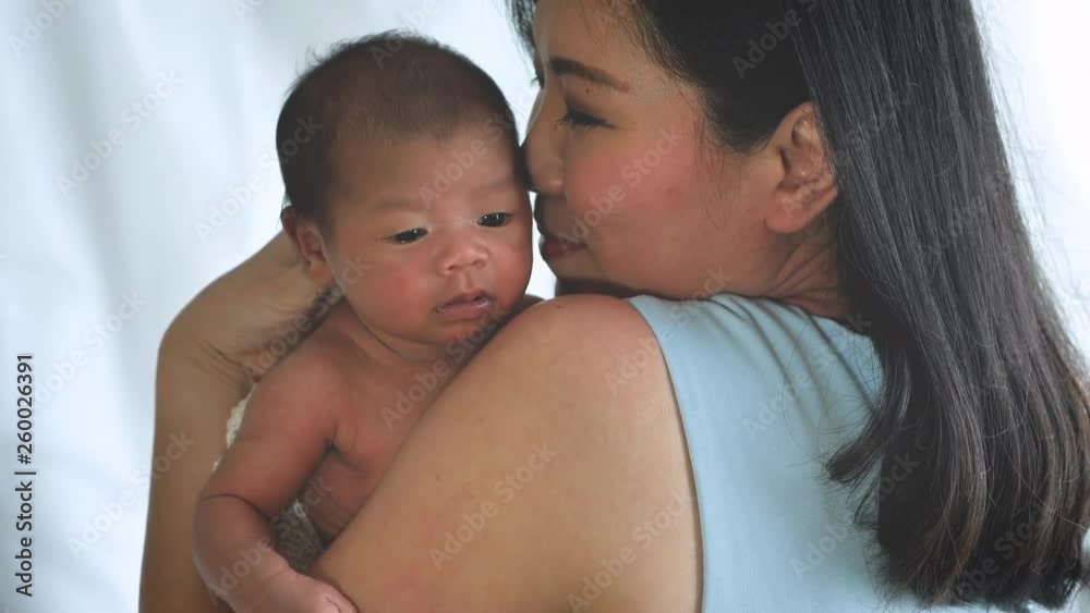 Close up portrait of beautiful young mother asian carrying little baby girl in home and sunlight in the morning. Healthcare, love, relationship concept Close up portrait of beautiful young mother asian carrying little baby girl in home and sunlight in the morning. Healthcare, love, relationship concept