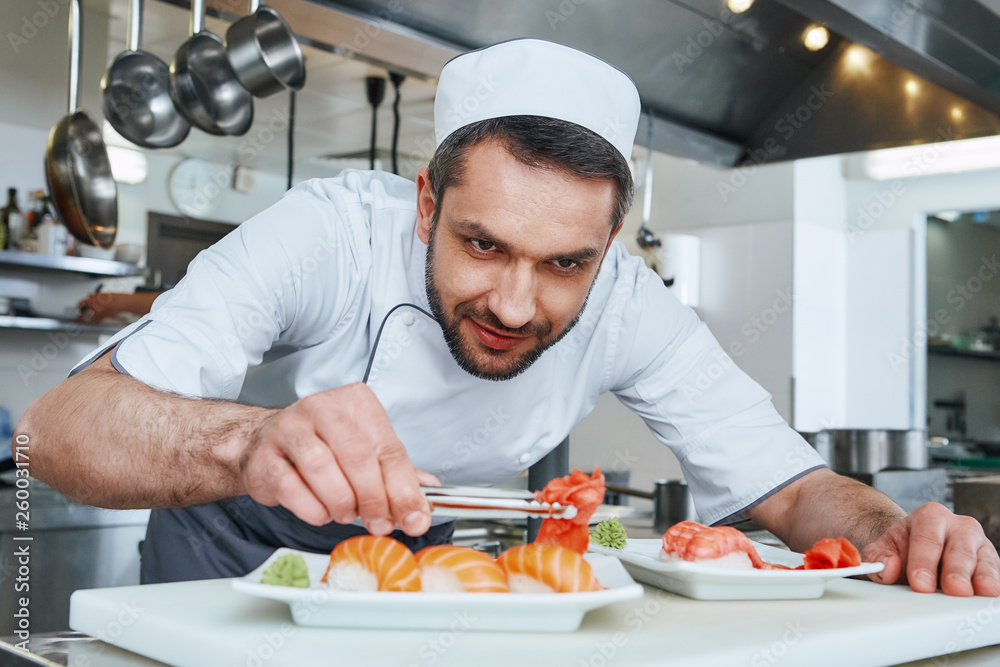 Made Fresh Always. Sushi master prepares sushi for serving in modern commercial kitchen Made Fresh Always. Sushi master prepares sushi for serving in modern commercial kitchen