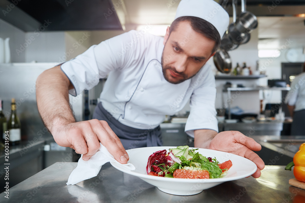 Food is our religion. Сook preparing dish for serving Food is our religion. Сook preparing dish for serving
