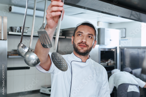 Be food safe. Cook chooses utensils for cooking in the kitchen of the restaurant