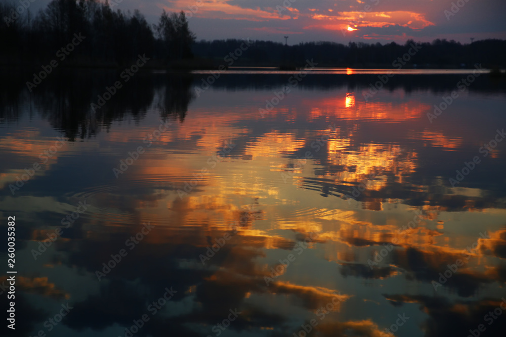 Sunrise over the lake reflected on the water surface.