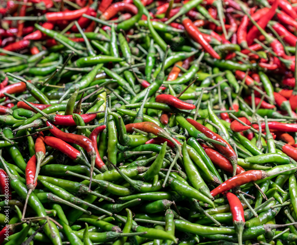 Red and Green Bird's Eye Chili mixed together at a market stall - Thai asian chilli pepper Capsicum Annuum used in malaysian singaporean indonesian and vietnamese cooking