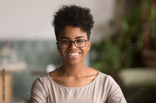 Headshot portrait of happy mixed race african girl wearing glasses photo