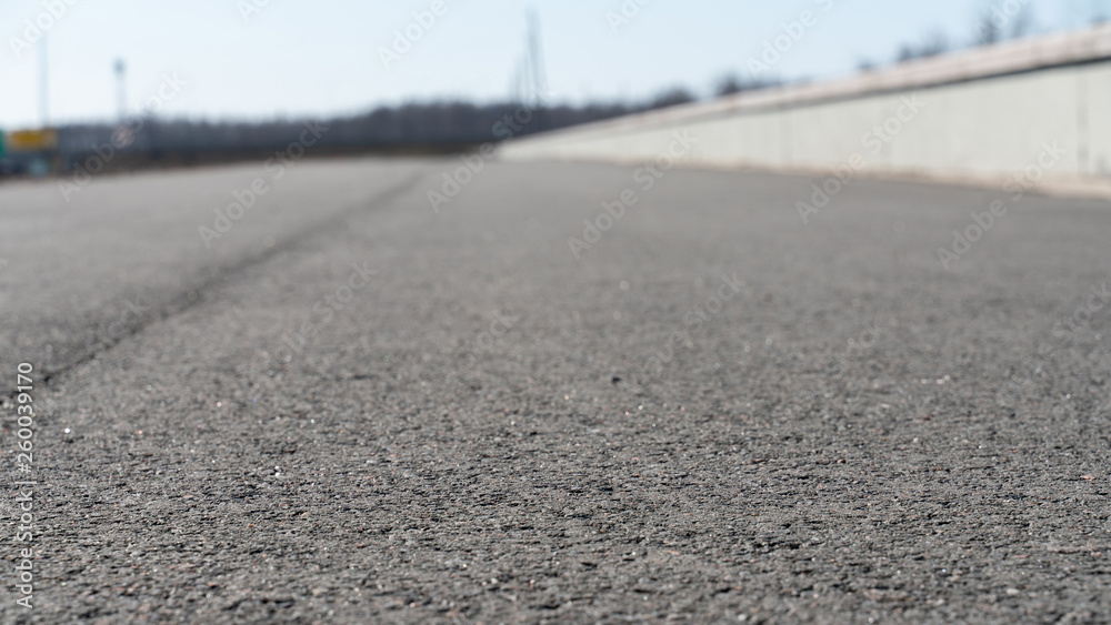 asphalt road with concrete fence going into the distance with a blurred background asphalt road with concrete fence going into the distance with a blurred background