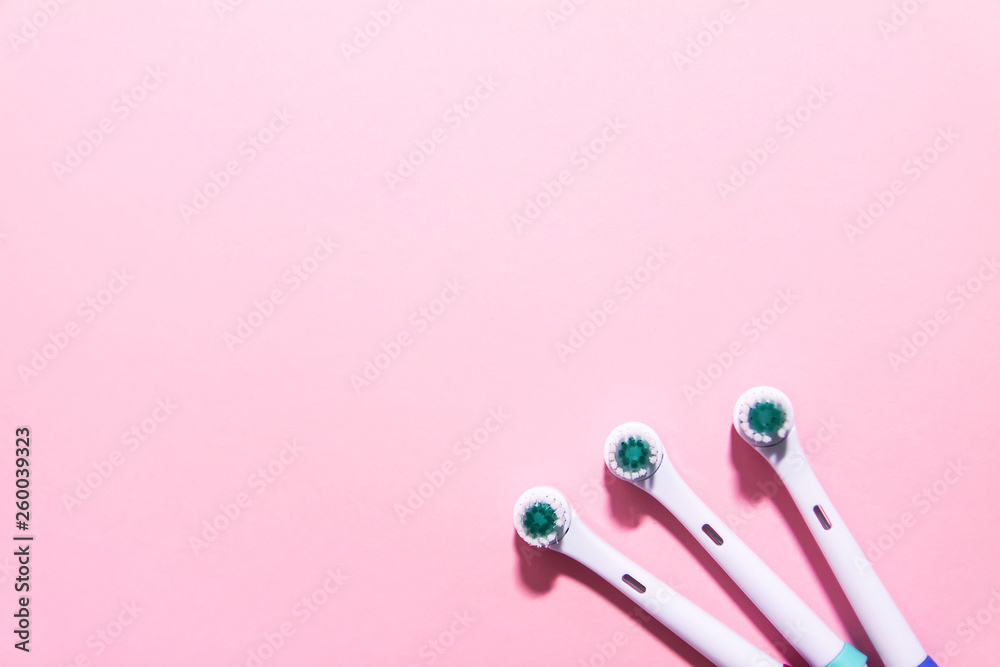 Electrical toothbrushes on a soft light pink background Electrical toothbrushes on a soft light pink background