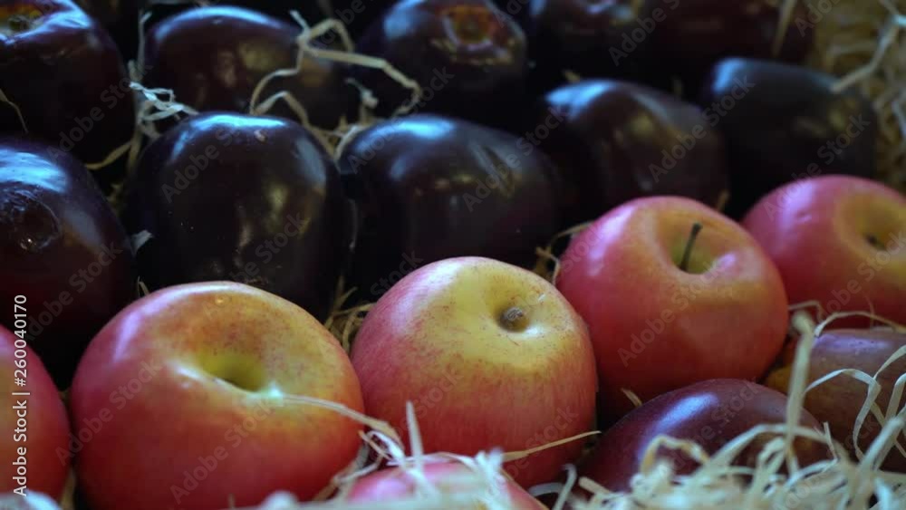 Dark red apples in a wooden box. Organic food store. Plastic fruits and vegetables. Vitamins. Healthy way of life. Diet. Vegetarianism. Meat replacement. Big harvest.