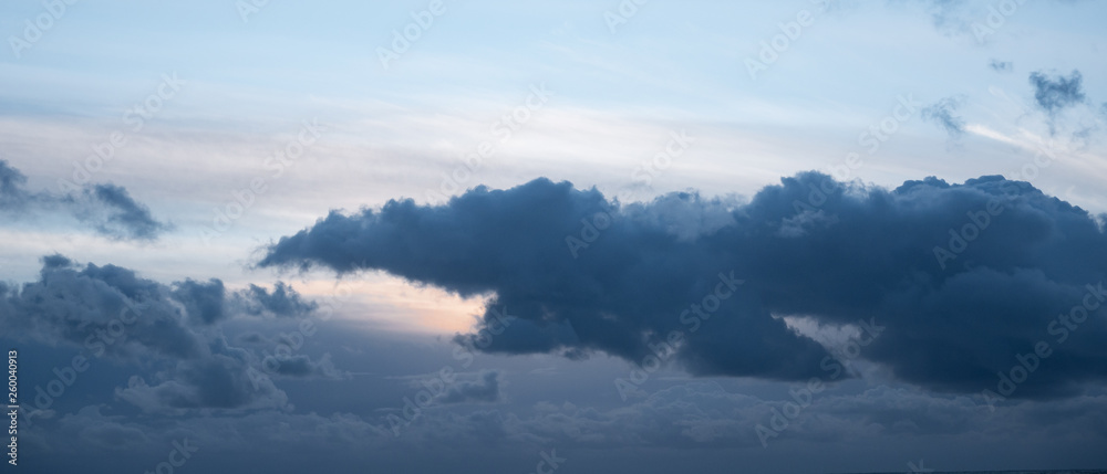 Dramatic, dark grey storm cloud in sky at dusk