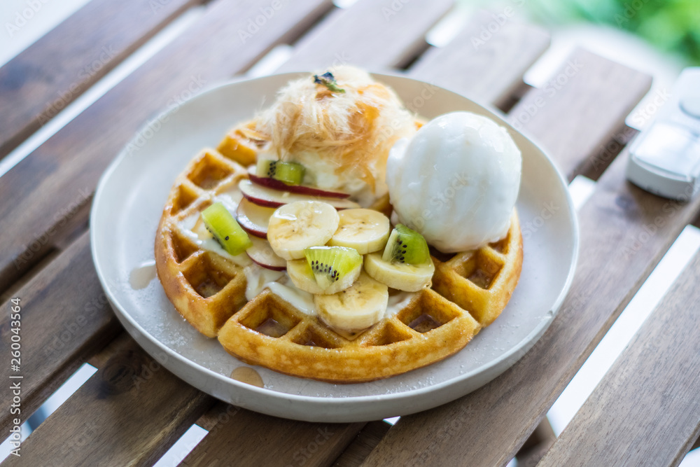 Golden brown waffle topped with ice cream Fruit sliced and whipped cream and Cotton Candy Golden brown waffle topped with ice cream Fruit sliced and whipped cream and Cotton Candy