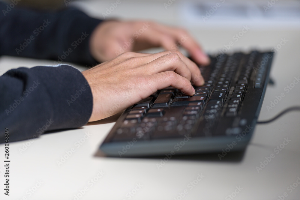 Hands of a young computer sicience student on a computer keyboard.