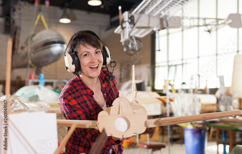 Woman in pilot headsets having fun with plane model