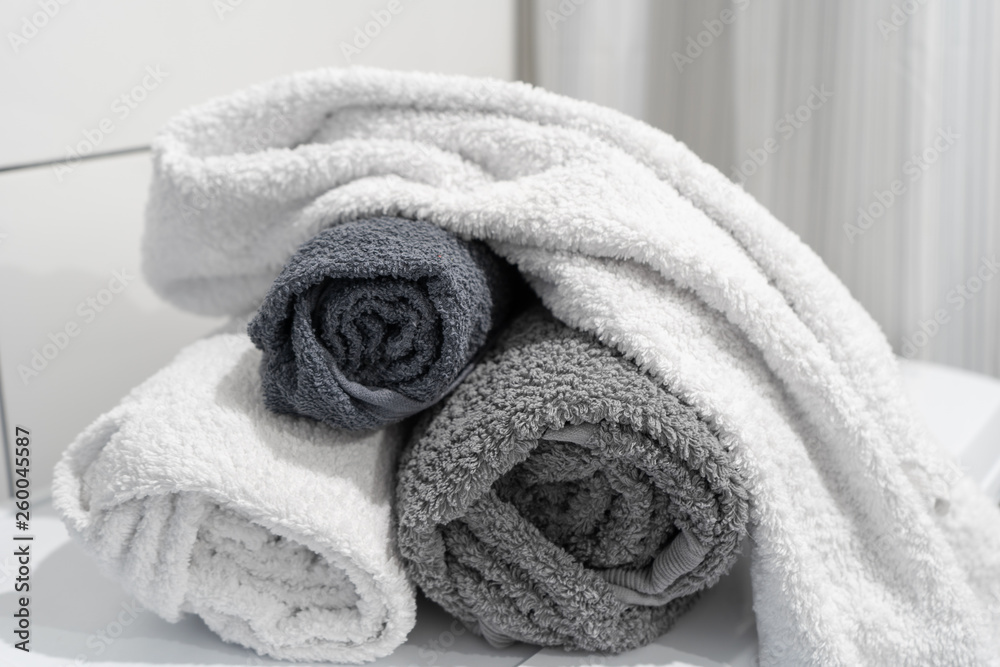 Clean rolled cotton towels of gray shades on the washing machine in the bathroom Clean rolled cotton towels of gray shades on the washing machine in the bathroom