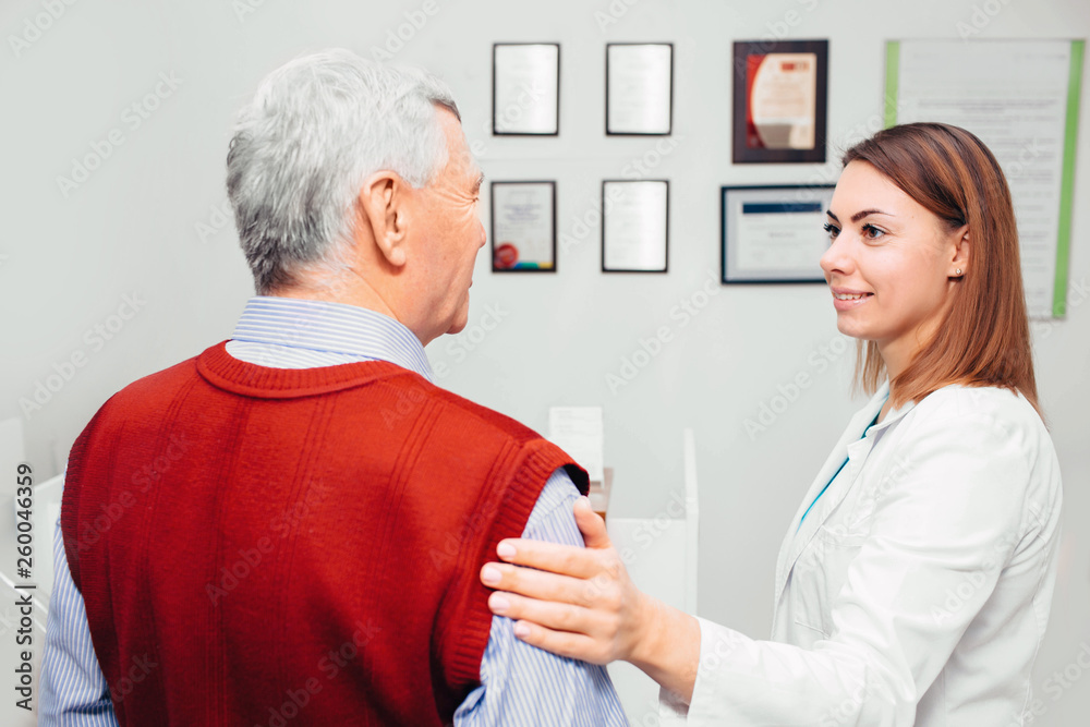 doctor comforting senior patient during a checkup at clinic