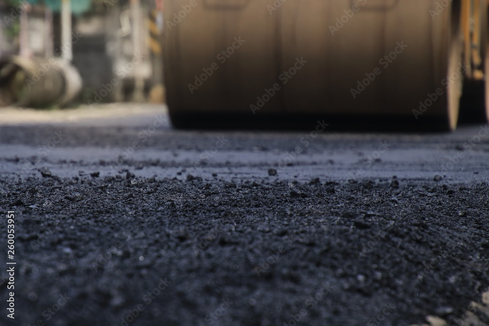 Road construction asphalt road by worker and roller machine. Asphalt road background Road construction asphalt road by worker and roller machine. Asphalt road background