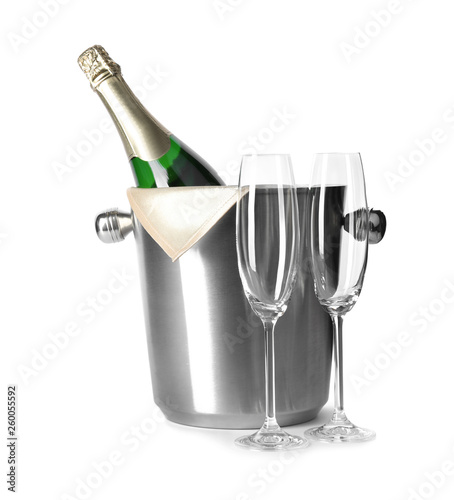 Empty glasses and metal bucket with bottle of champagne on white background