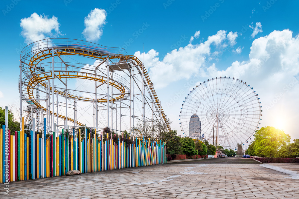 Roller coasters and ferris wheels in amusement parks。 - obrazy, fototapety, plakaty 