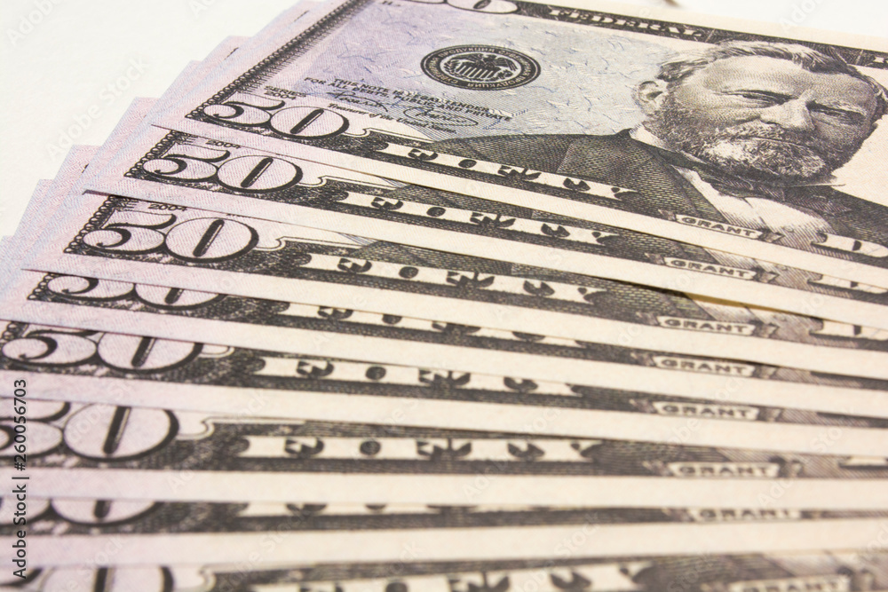 US currency, fan of fifty dollars on a white background, close-up photo with soft selective focus US currency, fan of fifty dollars on a white background, close-up photo with soft selective focus