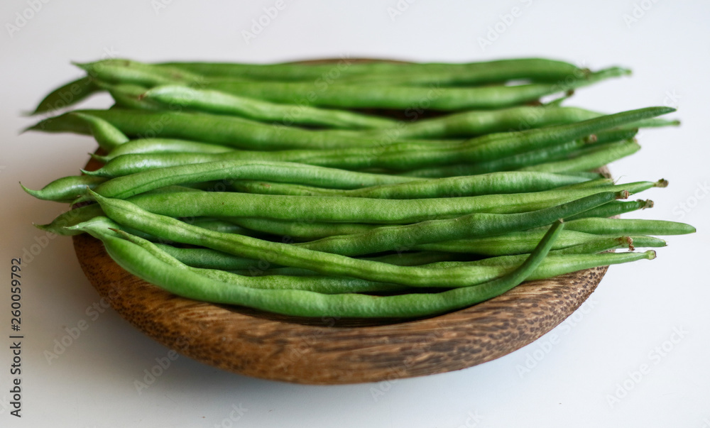 Phaseolus vulgaris or common bean on wooden plate. White background. Phaseolus vulgaris or common bean on wooden plate. White background.