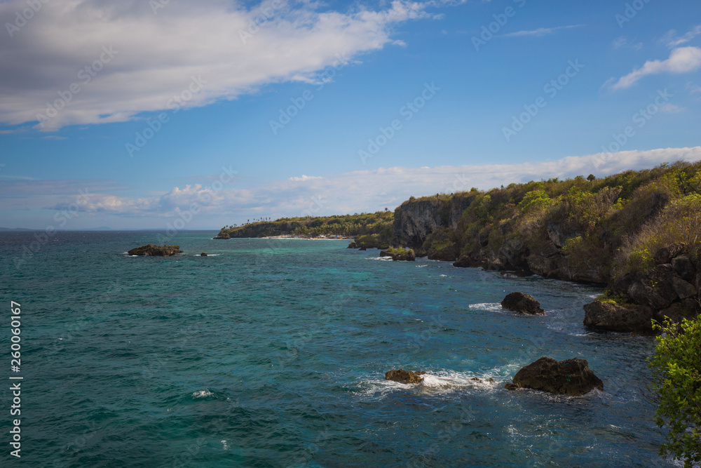 exotic rocky beach and coastline with blue and turquoise water, crystal clear water, a tropical tranquil relaxing scene