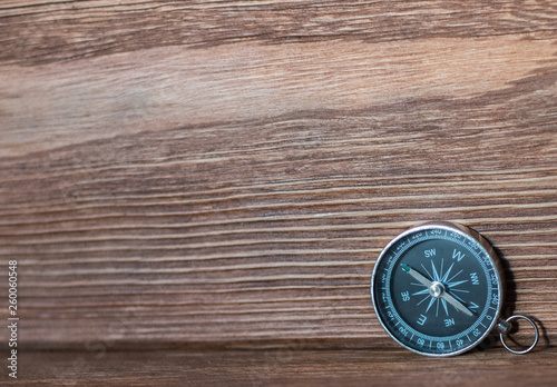 Compass with a rope on the background of the old board