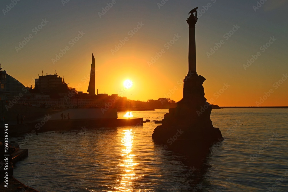 Embankment in the center of Sevastopol during sunset. In the rays of the setting sun, the Monument to the Sunken Ships and Monument to the Bayonet and Sail are visible.