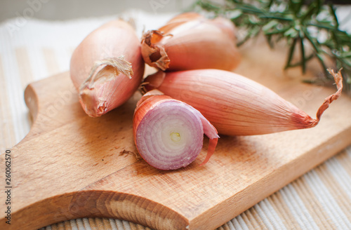Close-up of shallots with fresh rosemary on cutting board photo